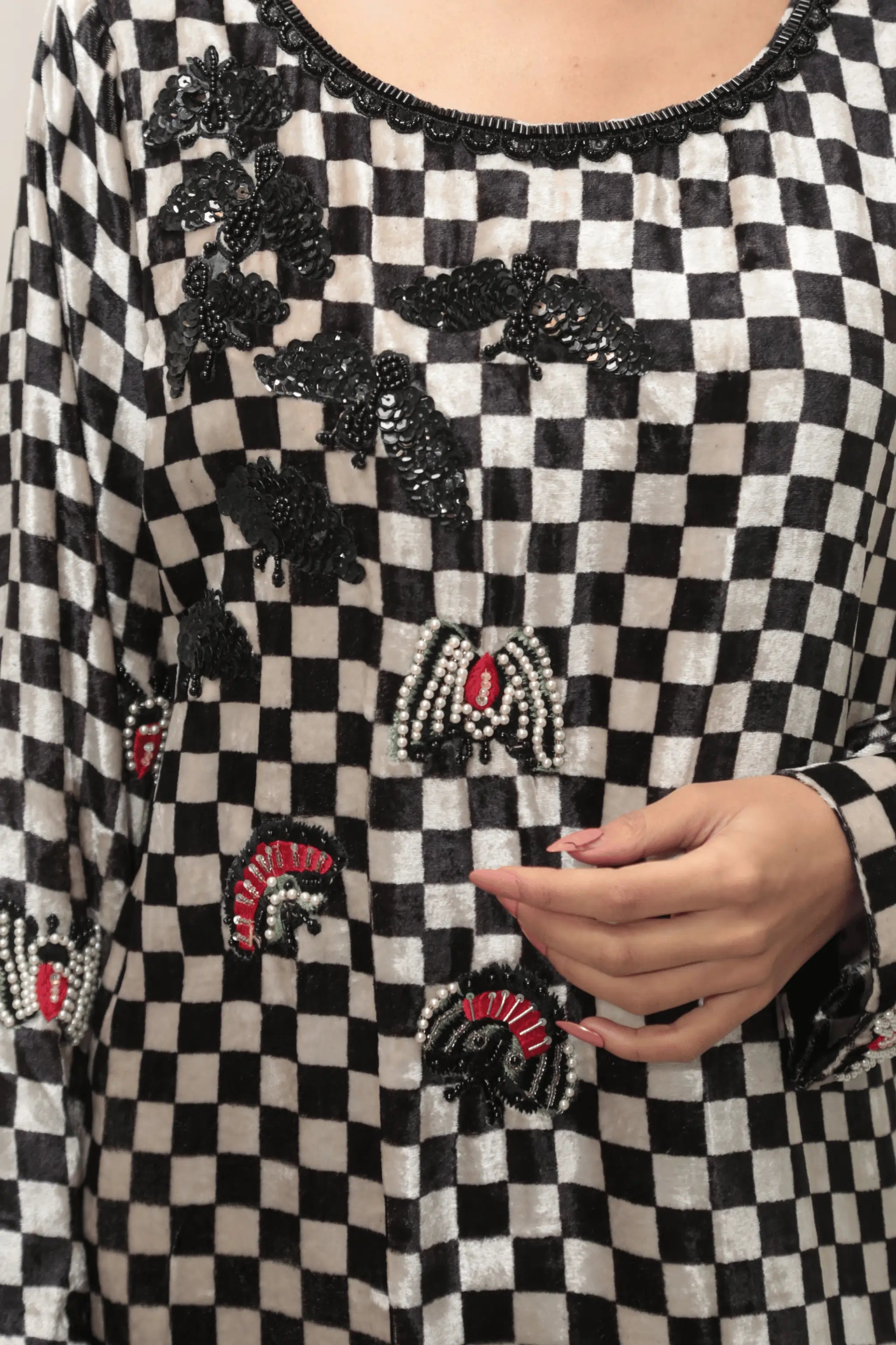 Detailed hand embroidery on velvet shirt hem with floral and architectural motifs