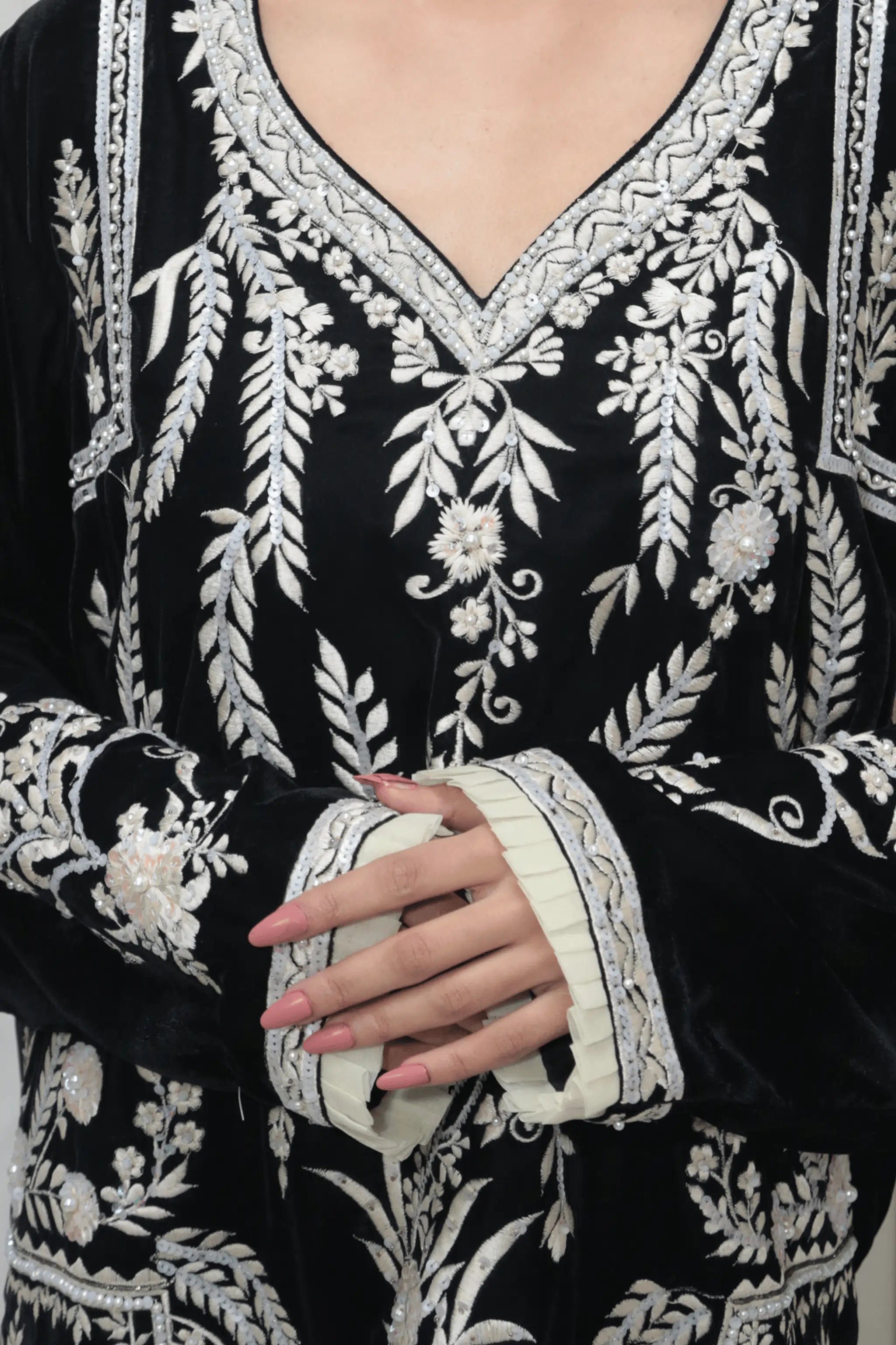 Close-up_of_detailed_embroidery_with_beads_sequins_and_pearls_on_black_velvet_shirt.