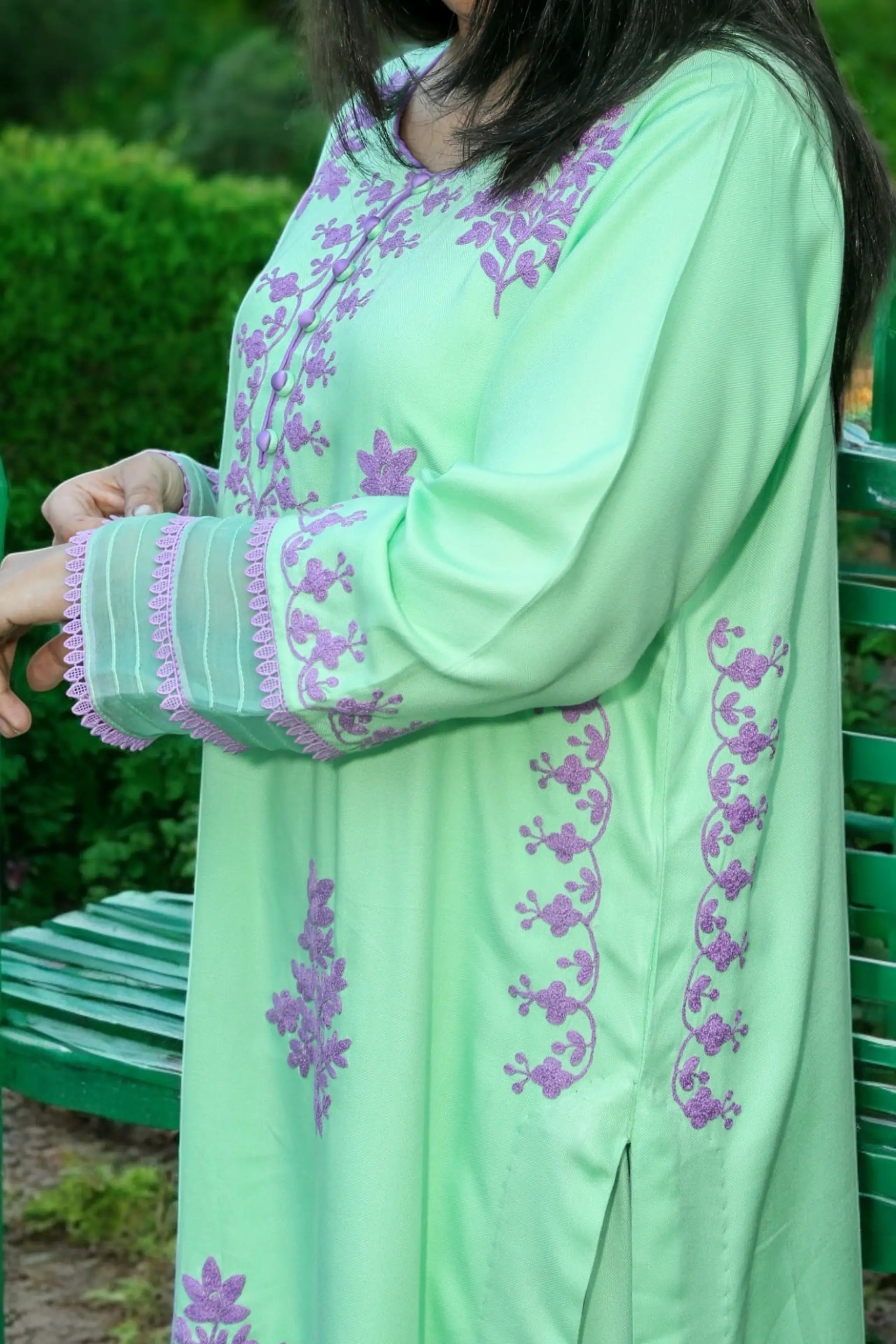 Close-up of mint green shirt with lavender floral embroidery